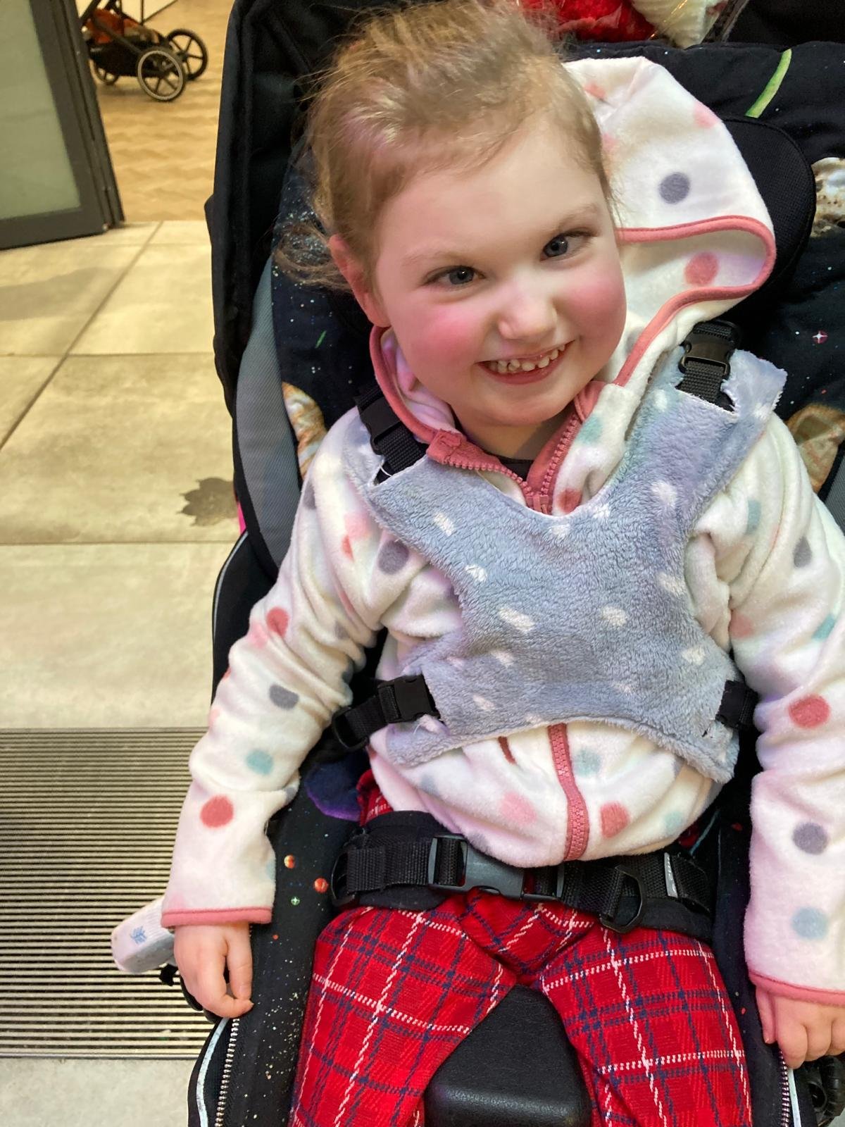Grace smiling in her wheelchair