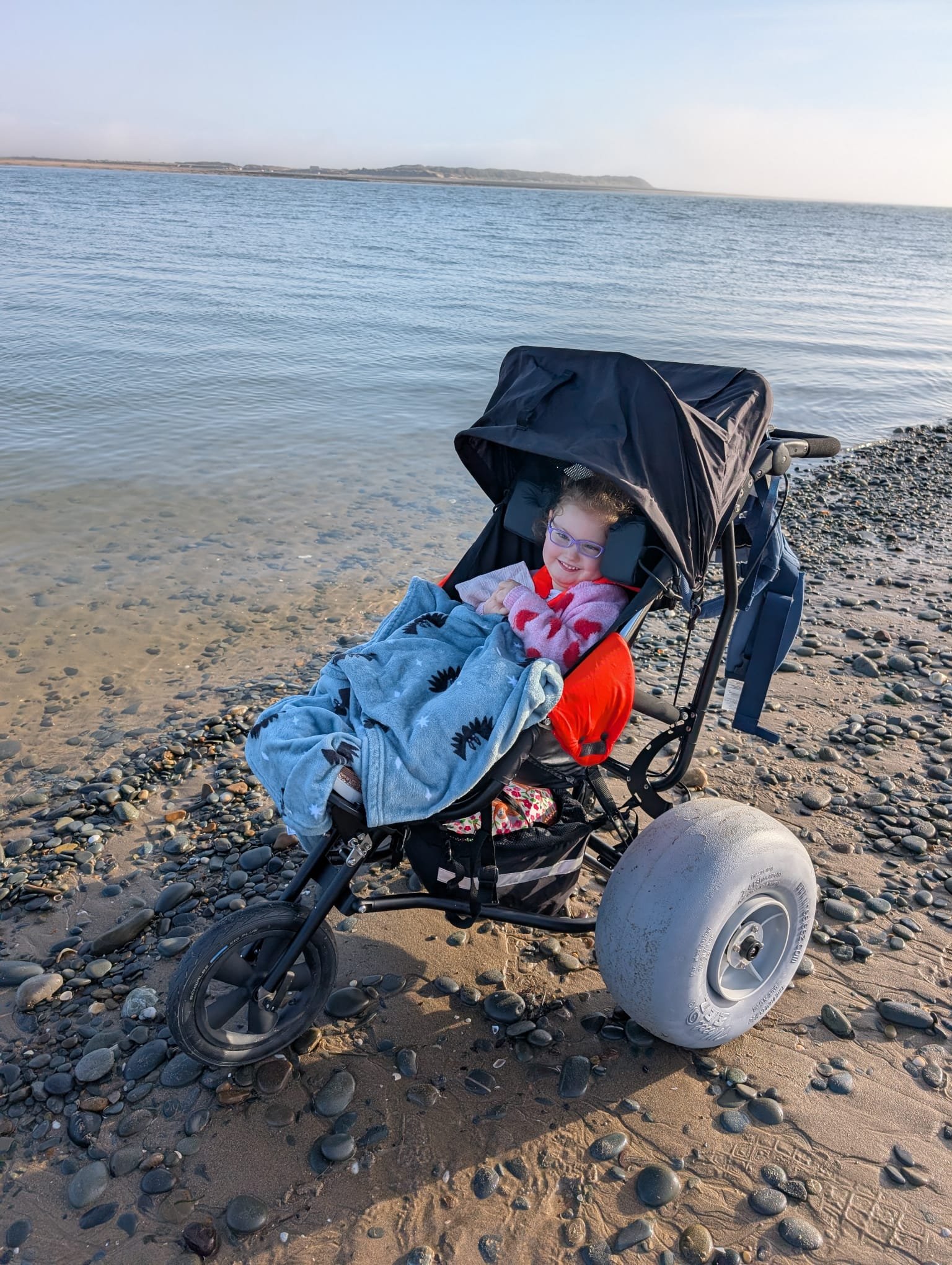 Grace at the beach in her specialist buggy
