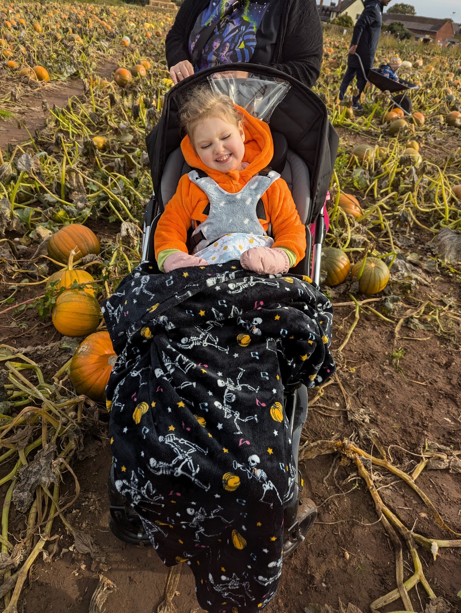 Grace at a pumpkin patch in her orange costume